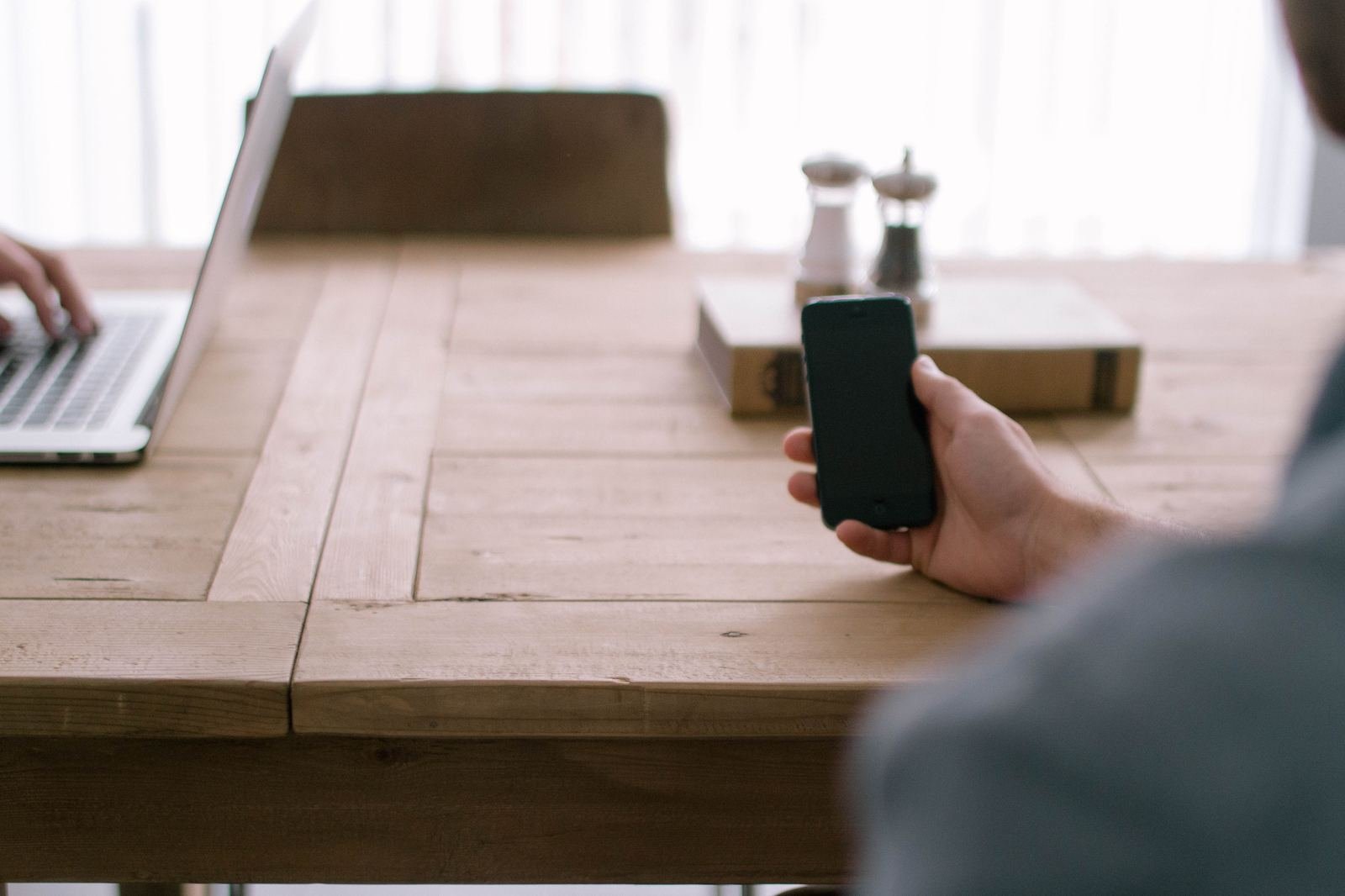 Founder reviewing go-to-market plans on phone and laptop